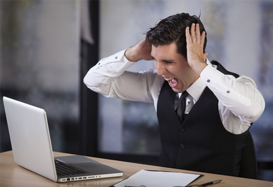 Business man screaming at his computer